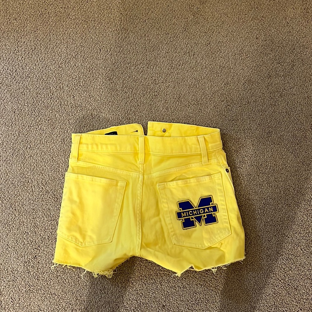 Yellow high waisted shorts with University of Michigan patch ironed on.